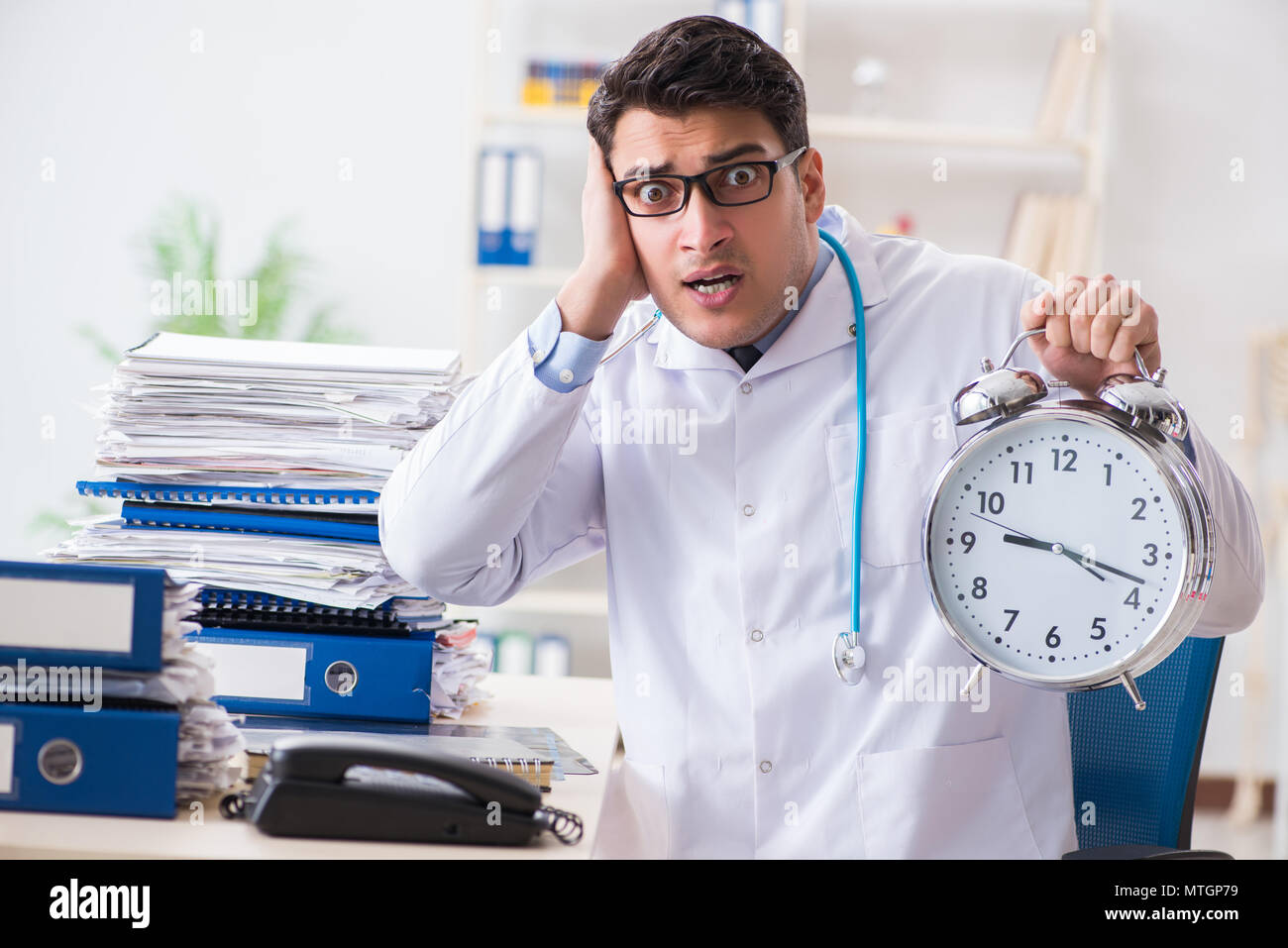 Doctor with alarm clock in urgent check-up concept Stock Photo - Alamy