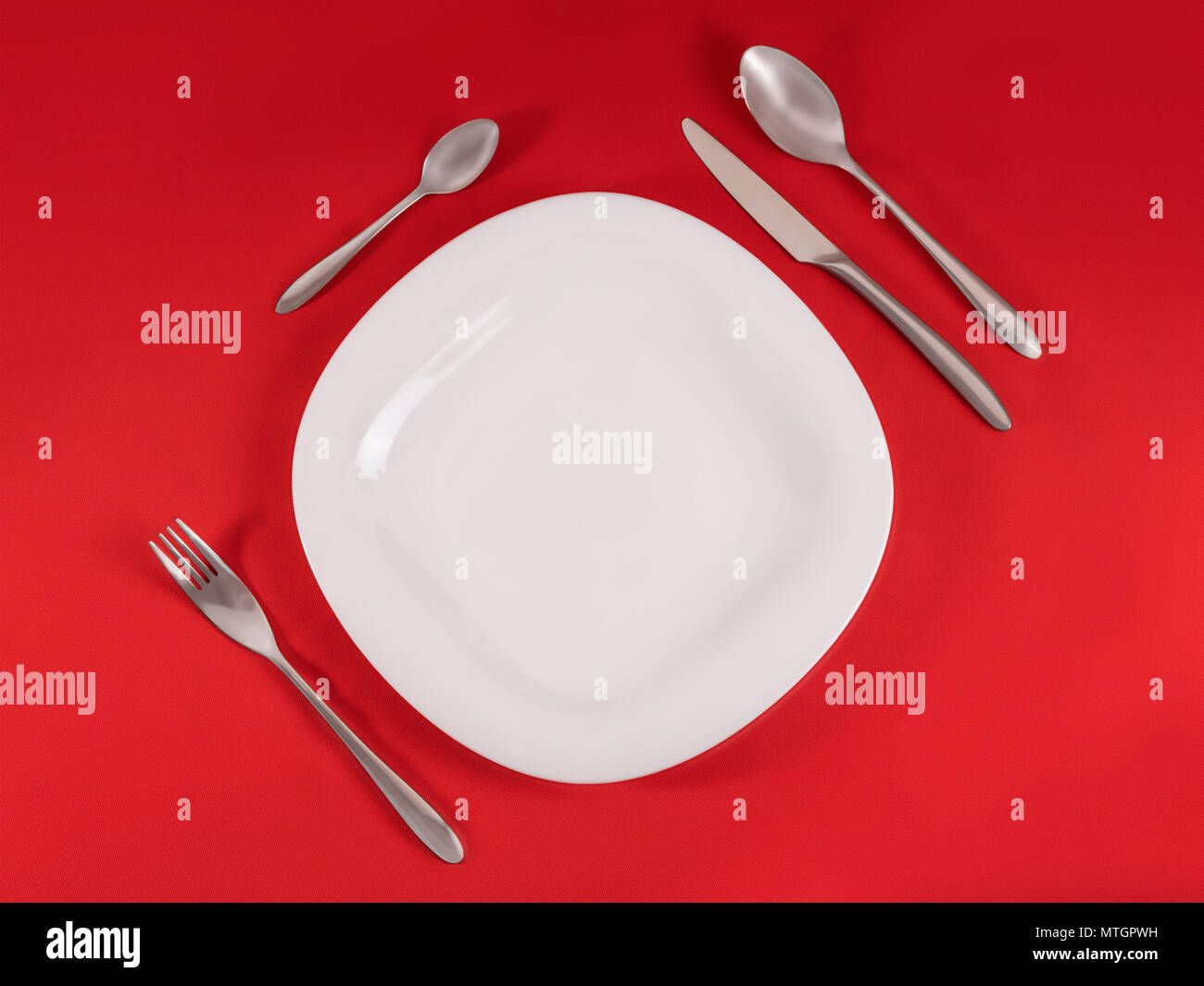 Perfect modern table setting on red napkin background. Top view, diagonal composition Stock Photo