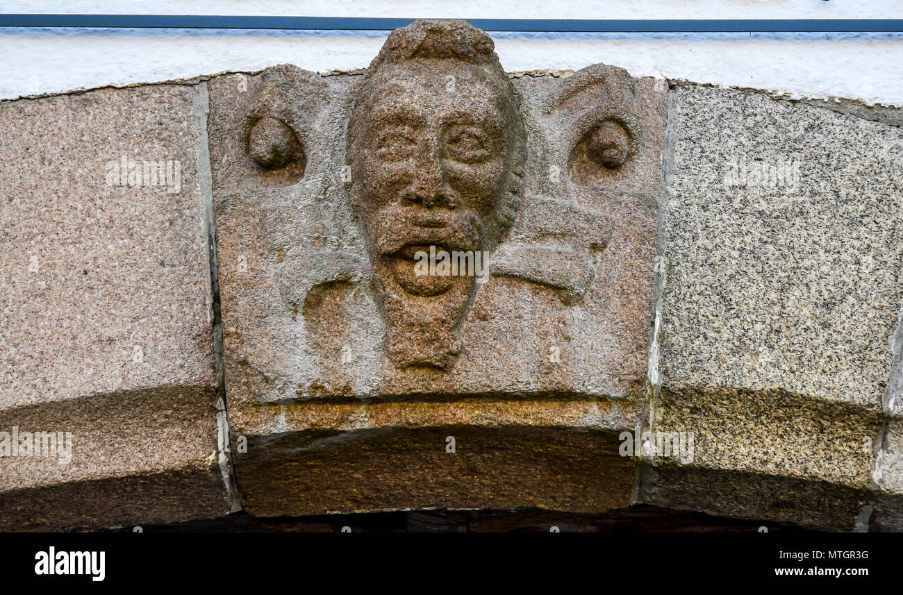 Carved stone head detail on a 15th Century building in Morlaix, Brittany, France. Stock Photo