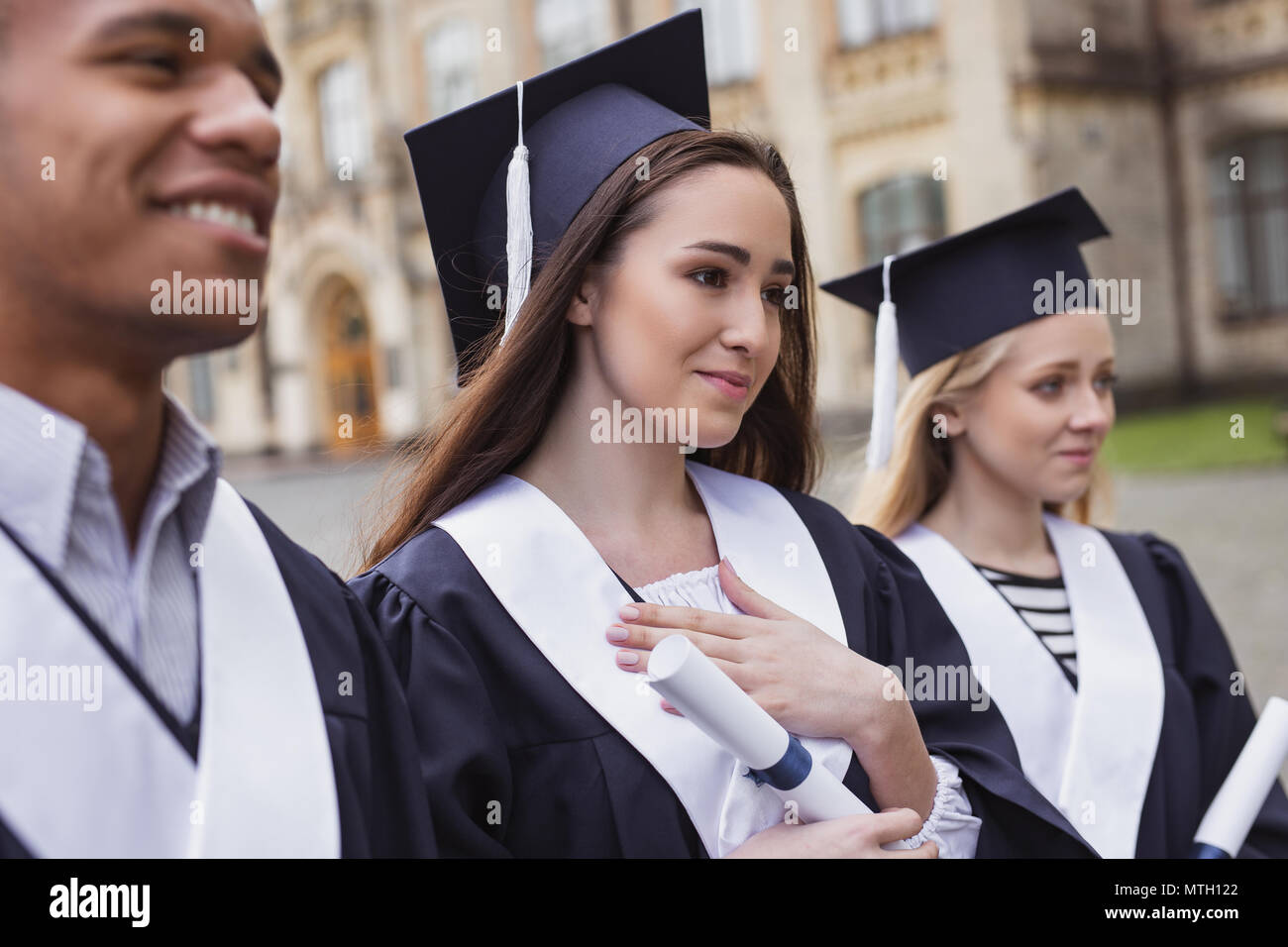 Students feeling thankful to their professors on graduation day Stock