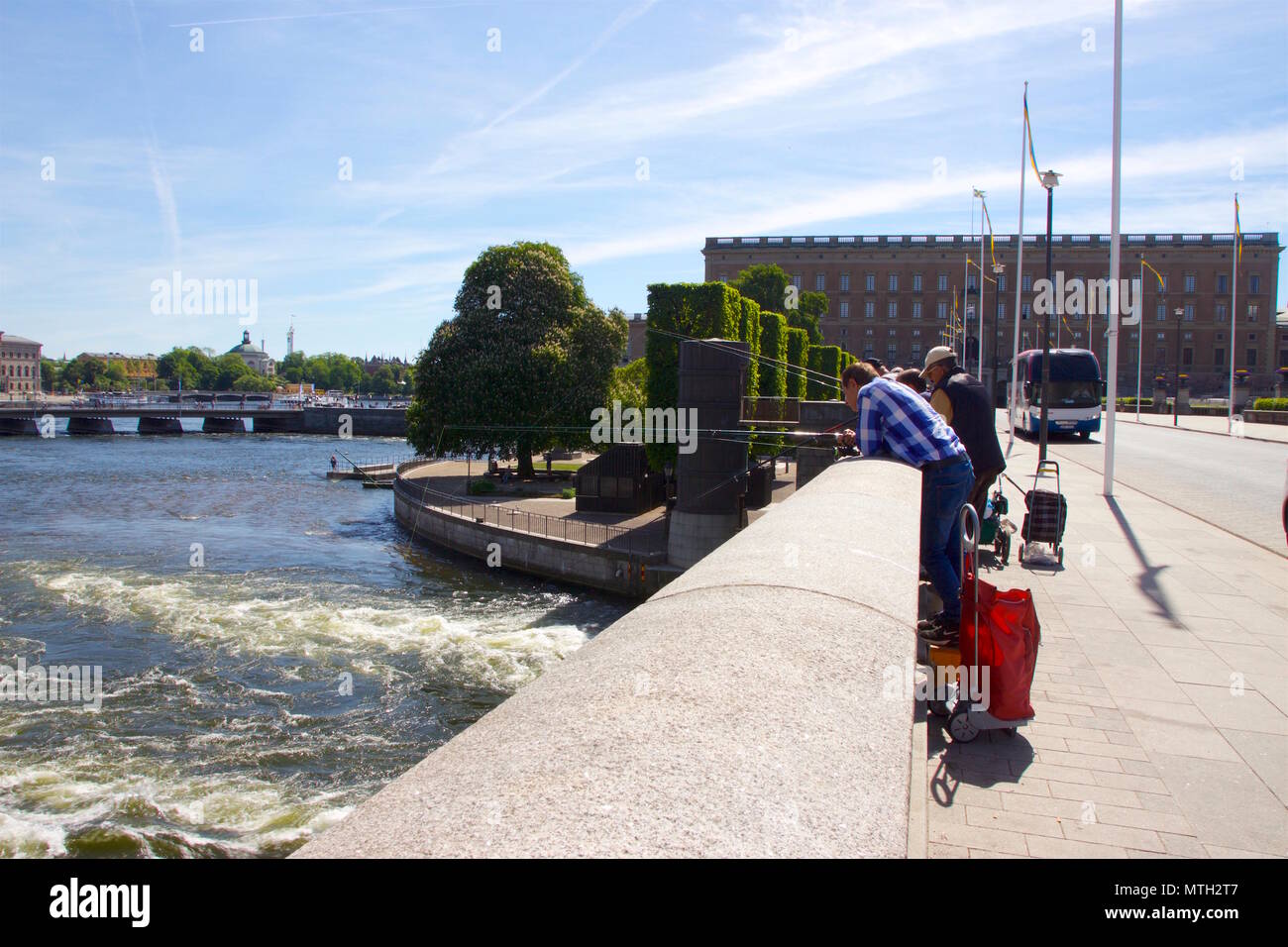 Urban fishermen or anglers fishing over the Riksbron bridge in Stockholm, where the fresh waters of Lake Malaren meet the waters of the Baltic sea Stock Photo