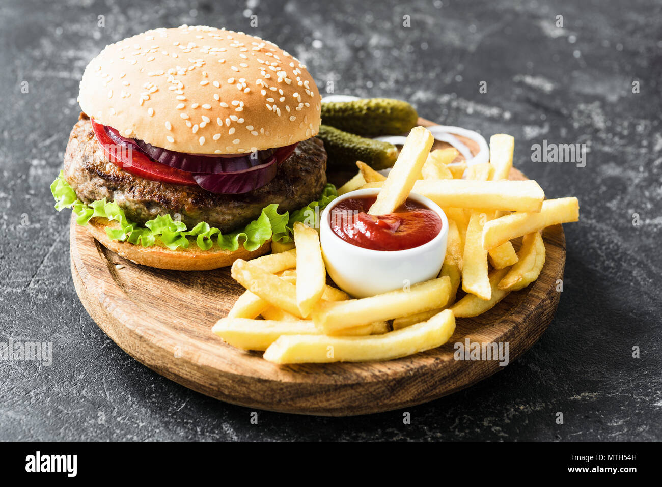 Beef burger with lettuce and tomato, potato fries and ketchup. Fast food Stock Photo