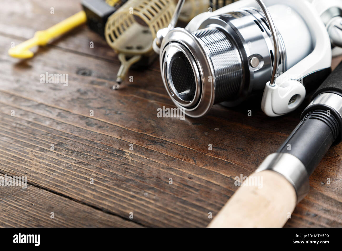 https://c8.alamy.com/comp/MTH5R0/fishing-tackle-fishing-spinning-spools-and-lures-on-dark-wooden-background-space-for-text-MTH5R0.jpg