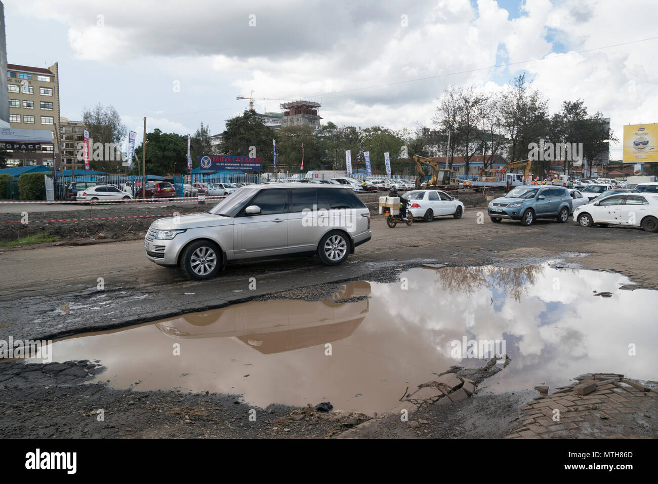 Traffic passing a large flooded pothole, Ngong Road, Nairobi, Kenya 16