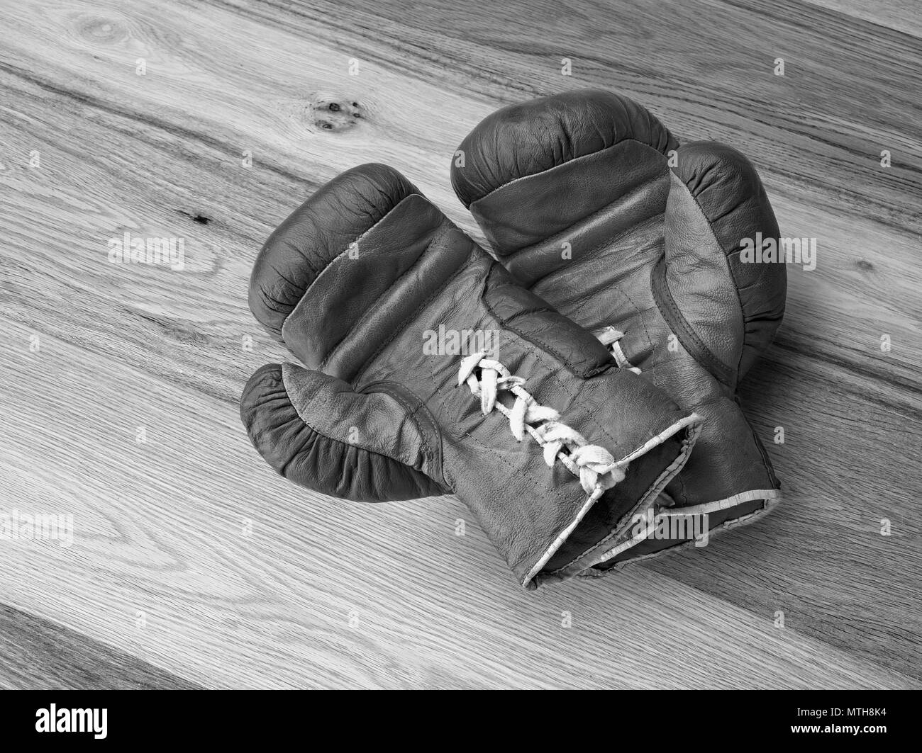 Old boxing gloves on Hardwood floor in renovated house - view from above Stock Photo