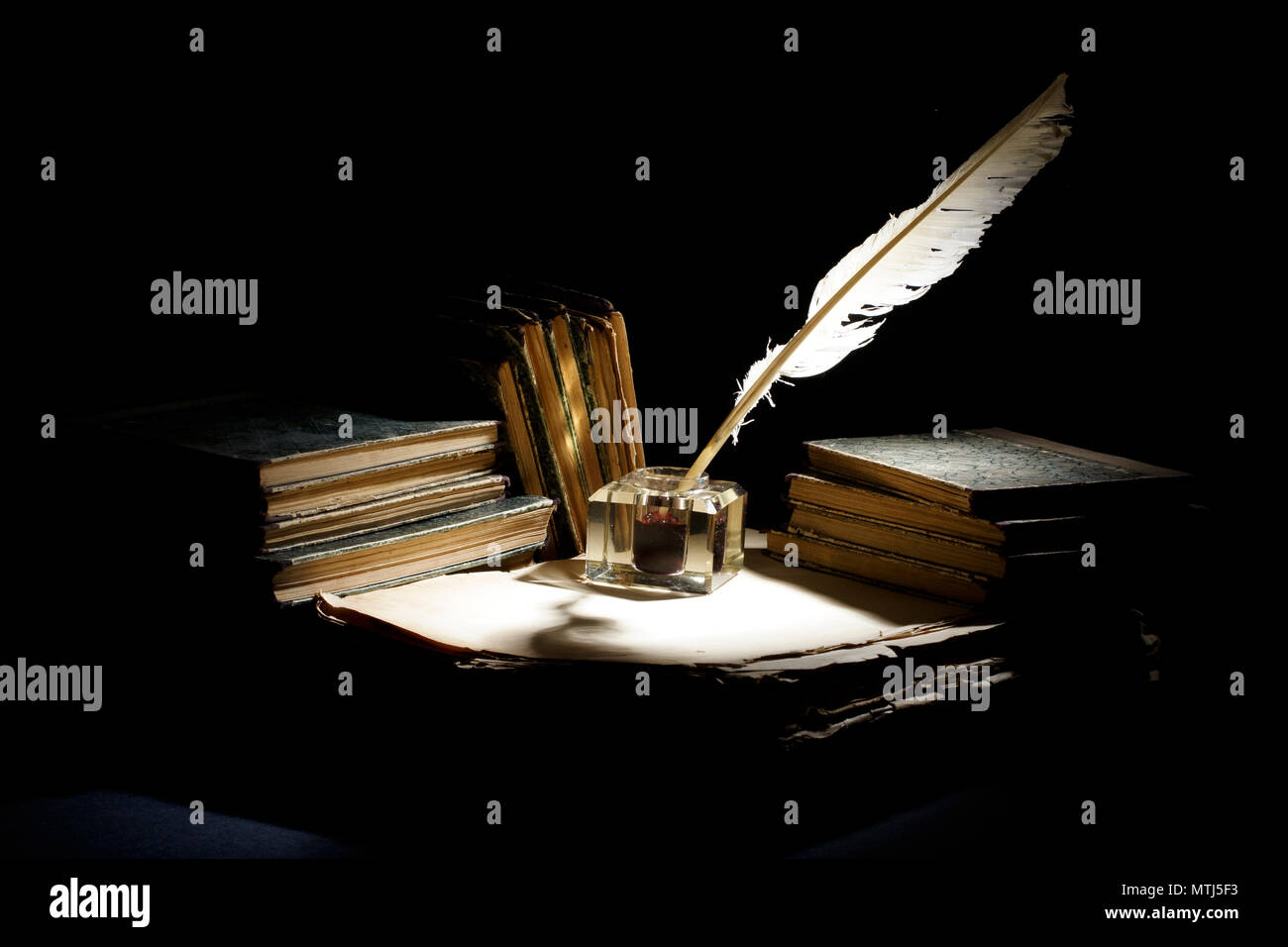 Vintage concept. Old fountain pen, books and inkwell on a black