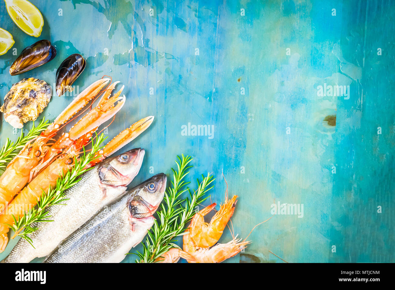 Fresh seafood and fish flat lay scene on blue background with copy ...