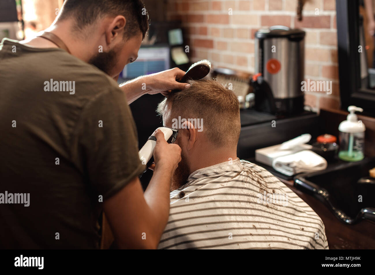 Barber and bearded man in barber shop Stock Photo