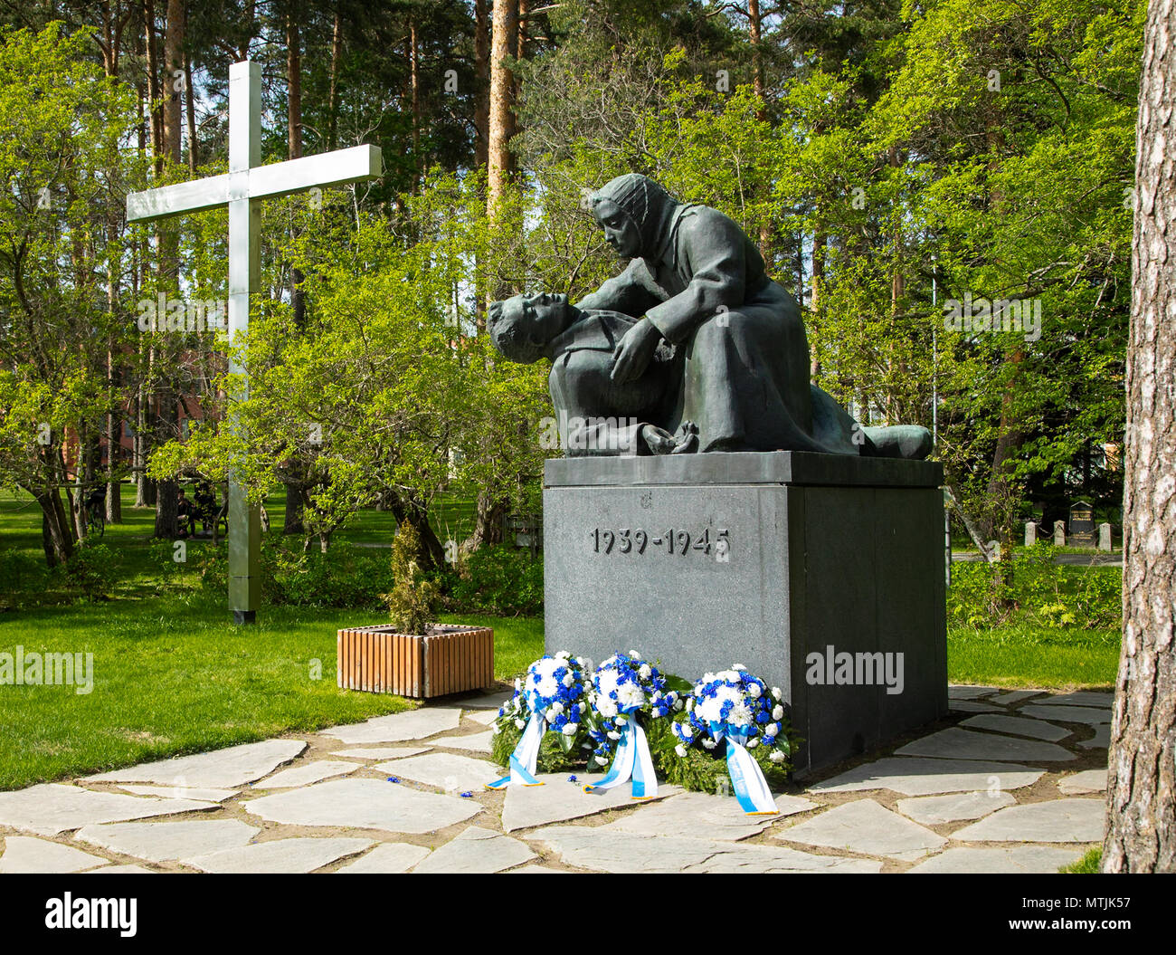 The monument of the fallen in Finland's wars at the cemetery of Kuopio, with wreaths of the Memorial Day placed in front of the sculpture. Stock Photo