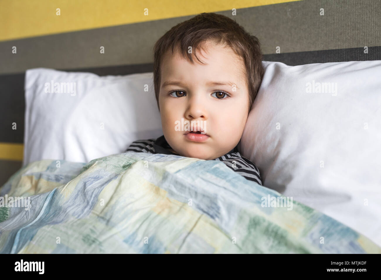 ill sad baby boy lying on bed Stock Photo Alamy