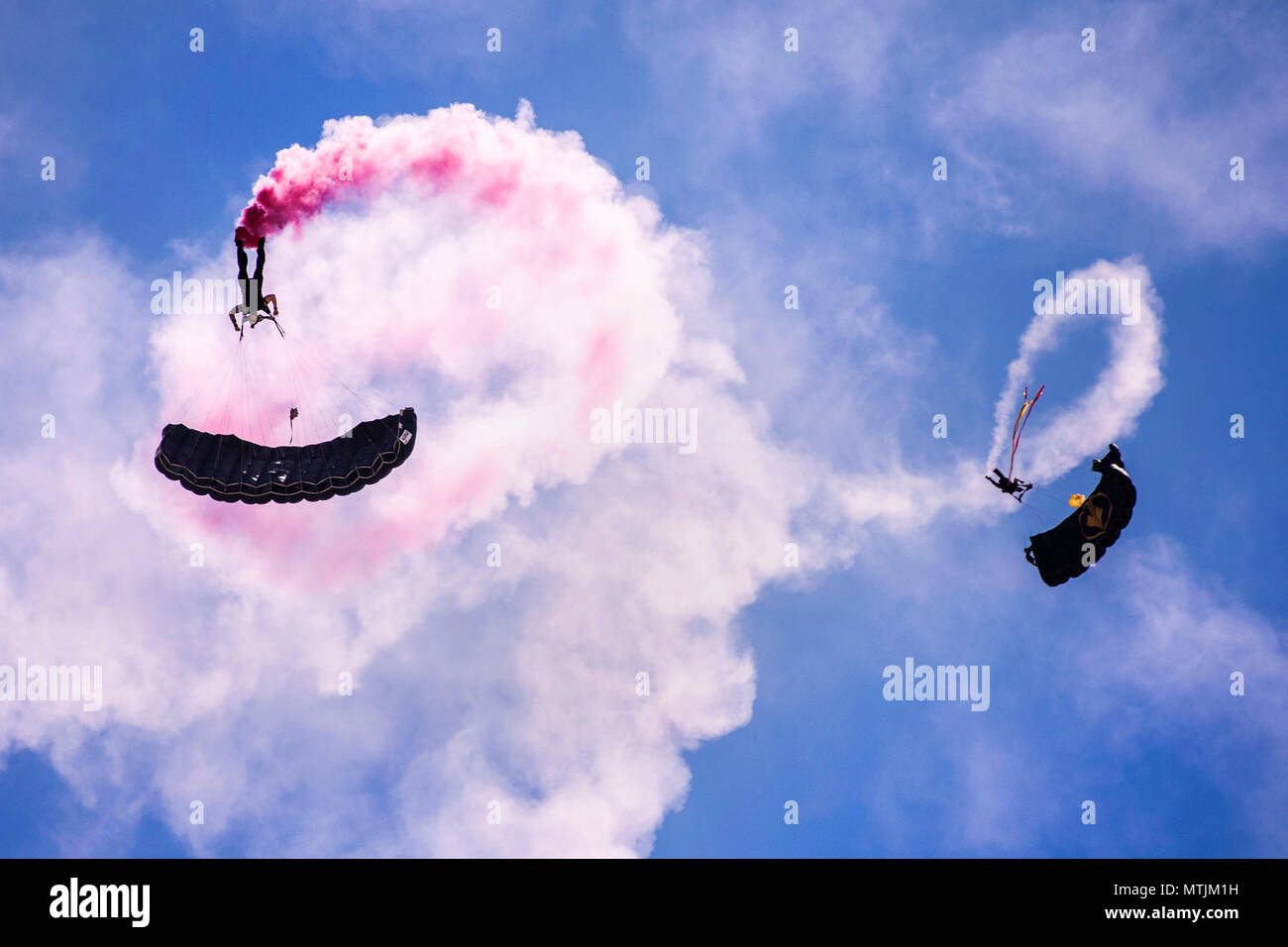 Two members of the U.S. Special Operations Command Para-Commandos parachute down during the Cannon Air Show, Space and Tech Fest at Cannon Air Force Base, N.M., May 26, 2018. The Para-Commandos are the only DoD Joint Service demonstration team consisting of members from every Military Service in SOCOM. (U.S. Air Force photo by Senior Airman Luke Kitterman/Released) Stock Photo