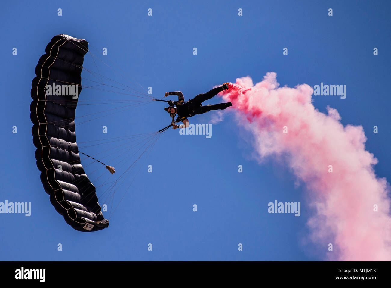 A member of the U.S. Special Operations Command Para-Commandos parachutes down during the Cannon Air Show, Space and Tech Fest at Cannon Air Force Base, N.M., May 26, 2018. The Para-Commandos are the only DoD Joint Service demonstration team consisting of members from every Military Service in SOCOM. (U.S. Air Force photo by Senior Airman Luke Kitterman/Released) Stock Photo