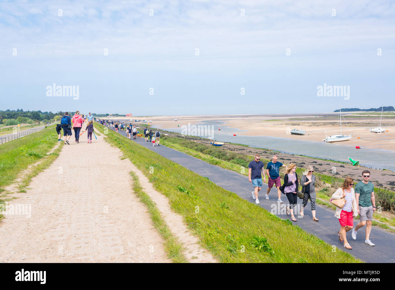 Wells-next-the-Sea, Norfolk, UK. 27th May 2018. People walking along the footpath leading to the beach of Wells on a sunny warm day during the Bank Ho Stock Photo