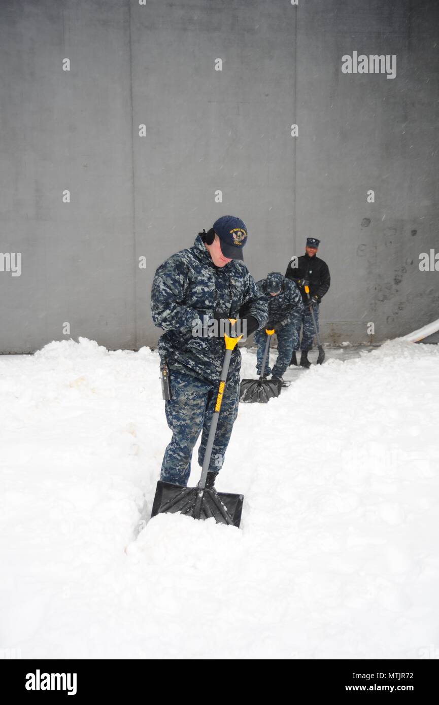 Aviation Boatswain's Mate (Launching and Recovery) Airman Zachery Pavey shovels snow aboard the