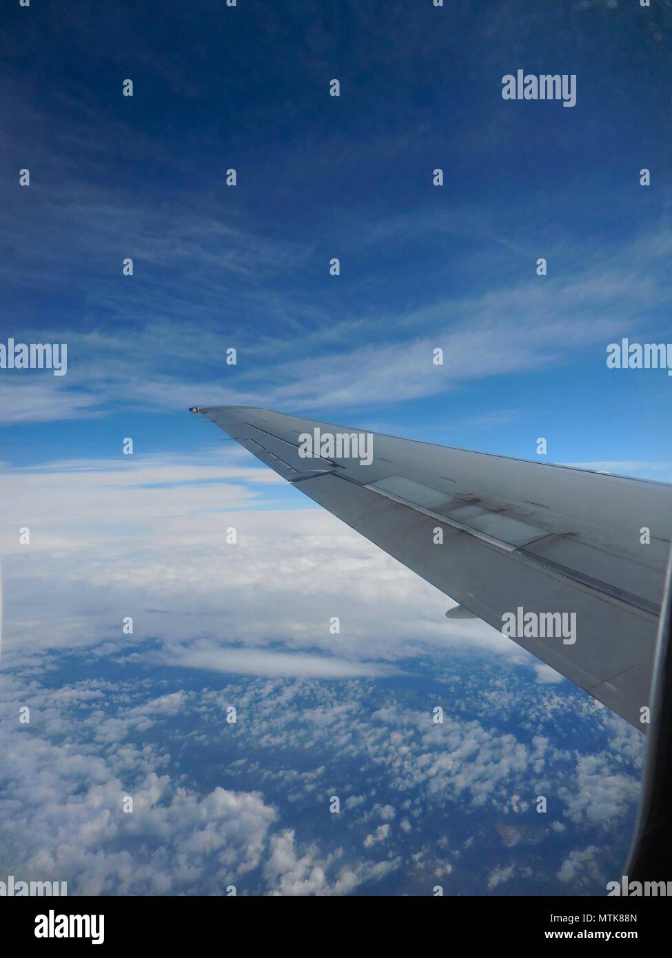 View of airplane wing and arial view of clouds Stock Photo - Alamy