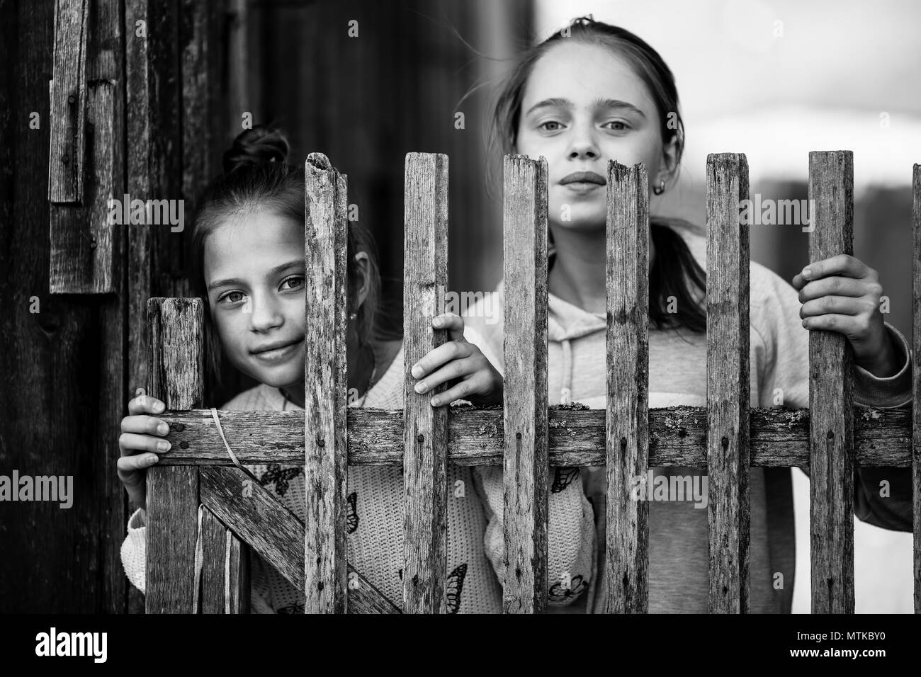 Two girls sisters or girlfriends having fun outdoors at Village. Looking into the camera. Black and white photo. Stock Photo