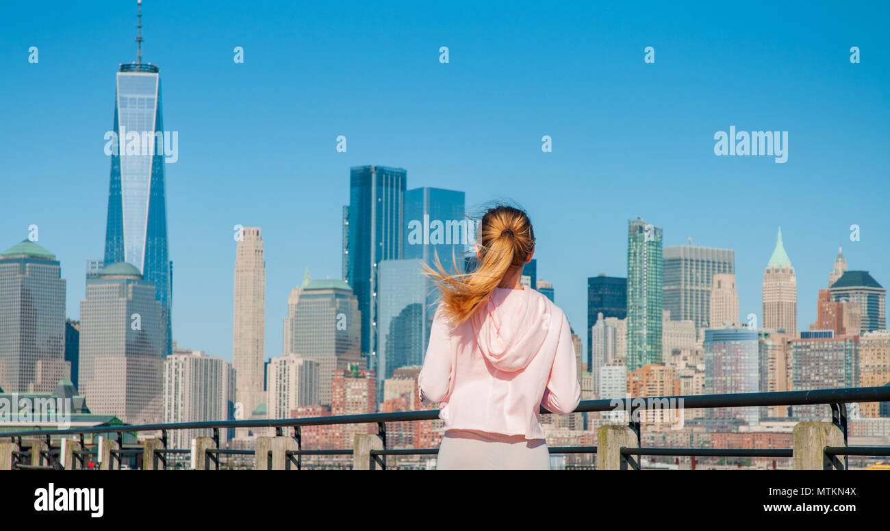 Beautiful woman is walking in sunny day in New York. View from the back. Stock Photo