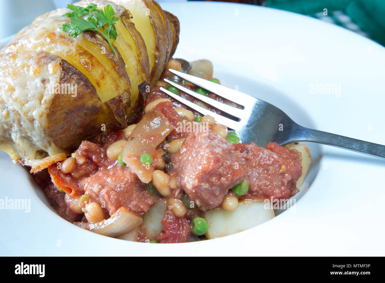 A portion of Corned Beef hash served with a cheese topped Hasselback