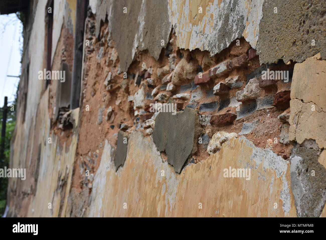Weathered Old Wall with Exposed Bricks and Peeling Plaster Texture Stock Photo