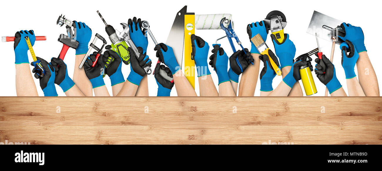 hand with blue working gloves and various diy handyman tools behind wooden planks with copy space isolated on white background Stock Photo