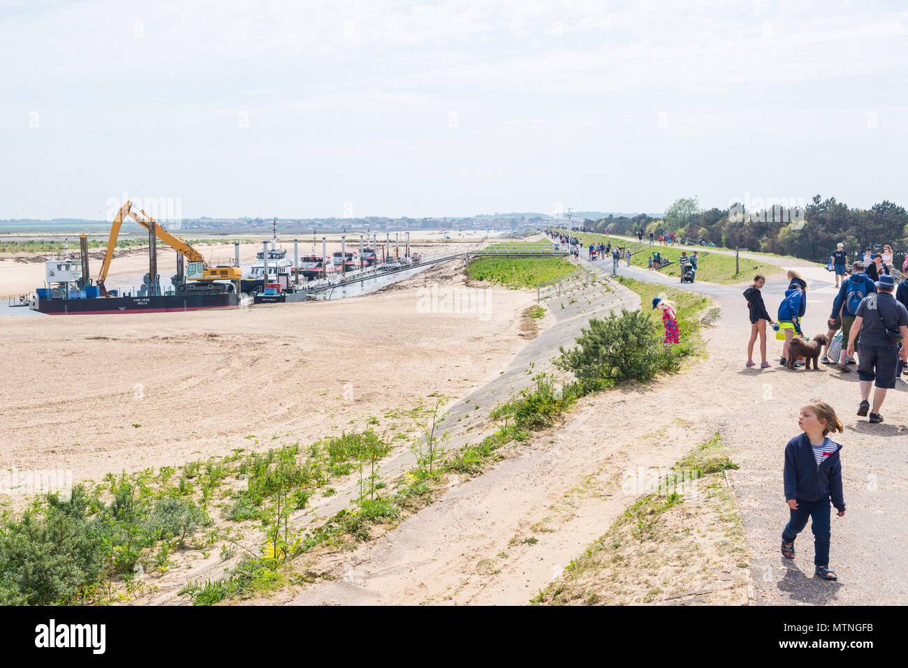 Wells-next-the-Sea, Norfolk, UK. 27th May 2018. People walking along the footpath leading to the beach of Wells on a sunny warm day during the Bank Ho Stock Photo