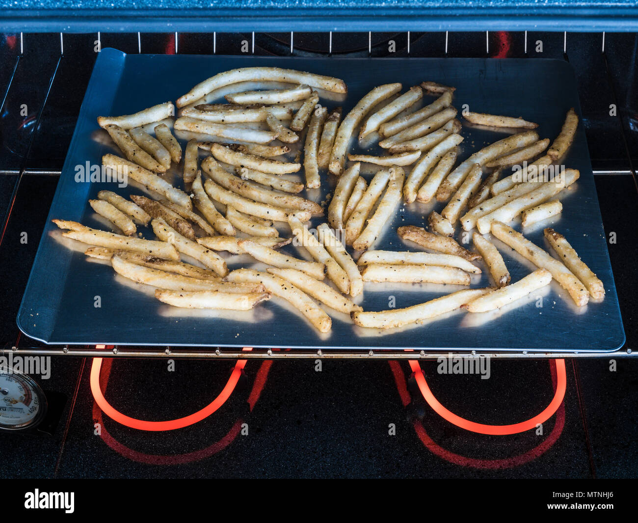 french fries on cookie sheet in electric oven Stock Photo Alamy