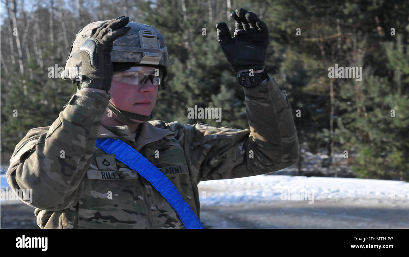 A U.S. Soldier gives driving signals to (not pictured) a Soldier, 1st Battalion, 8th Infantry Regiment, 3rd Armored Brigade Combat Team, while offloading it from the railhead in Zagan, Poland, January 11, 2017. The arrival of 3rd Arm. Bde. Cmbt. Tm., 4th Inf. Div., marks the start of back-to-back rotations of armored brigades in Europe as part of Atlantic Resolve. The vehicles and equipment, totaling more than 2,700 pieces, will be shipped to Poland for certification before deploying across Europe for use in training with partner nations. This rotation will enhance deterrence capabilities in t Stock Photo