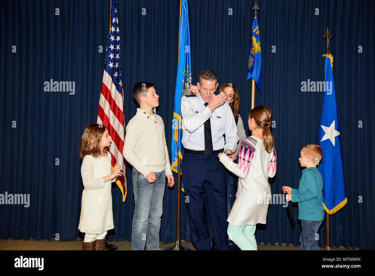 Col. Quenten M. Esser, 114th Operations Group commander, is assisted by his wife, Jennifer, and children, Bryson, Ellie, Paige, and Tate, in pinning on his new rank during his promotion ceremony Jan. 8, 2017 at Joe Foss Field, S.D. Esser assumed command of the 114th Operations Group from Col. Gregory Lair on May 1, 2016.(U.S. Air National Guard photo by Master Sgt. Luke Olson/Released) Stock Photo