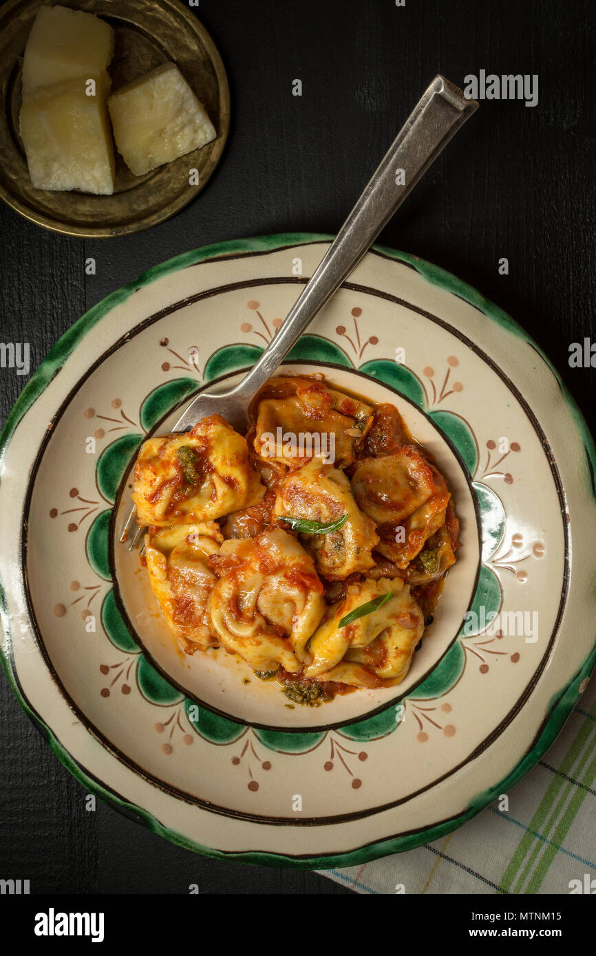 Fresh Homemade Tortellini with Tomato Sauce and Mozzarella Cheese on Rustic Plate Stock Photo
