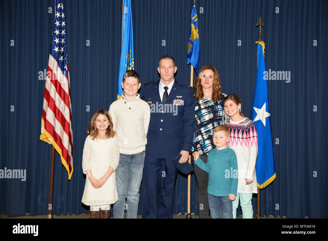 Col. Quenten M. Esser, 114th Operations Group commander,stands next to his wife, Jennifer, and children, Bryson, Ellie, Paige, and Tate, during his promotion ceremony Jan. 8, 2017 at Joe Foss Field, S.D. Esser assumed command of the 114th Operations Group from Col. Gregory Lair on May 1, 2016.(U.S. Air National Guard photo by Master Sgt. Luke Olson/Released) Stock Photo