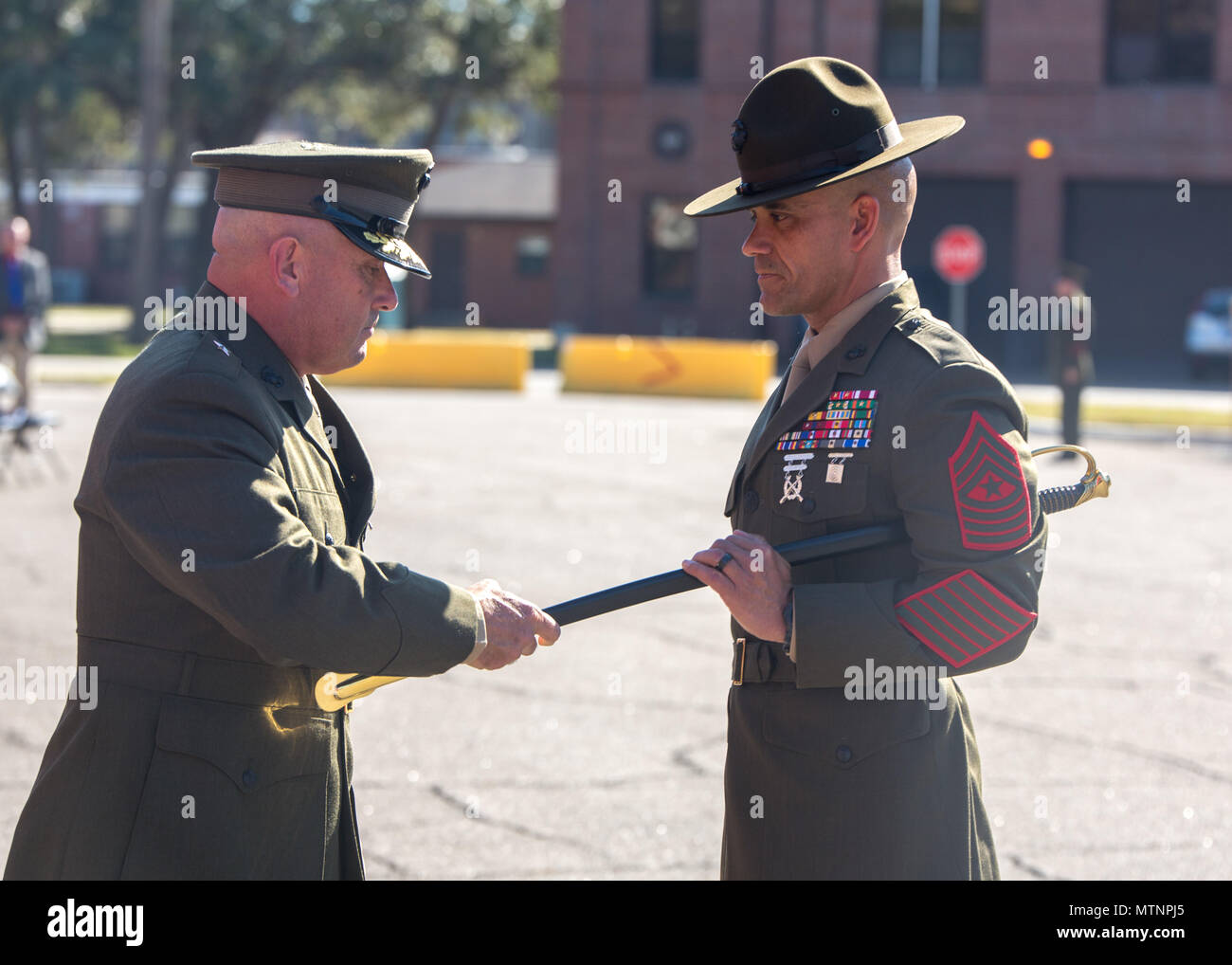 Sgt. Maj. Rafael Rodriguez accepts a noncommissioned officer sword from Brig. Gen. Austin E. Renforth, commanding general of Marine Corps Recruit Parris Island, S.C., on Jan. 13, 2017, during a relief and appointment ceremony for the Marine Corps Recruit Depot Parris Island and Eastern Recruiting Region sergeant major. The passing of the sword symbolizes the transfer of responsibilities and accountability from the outgoing senior-enlisted advisor to the incoming. Sgt. Maj. Angela M. Maness relinquished her post as the Marine Corps Recruit Depot Parris Island and Eastern Recruiting Region serge Stock Photo