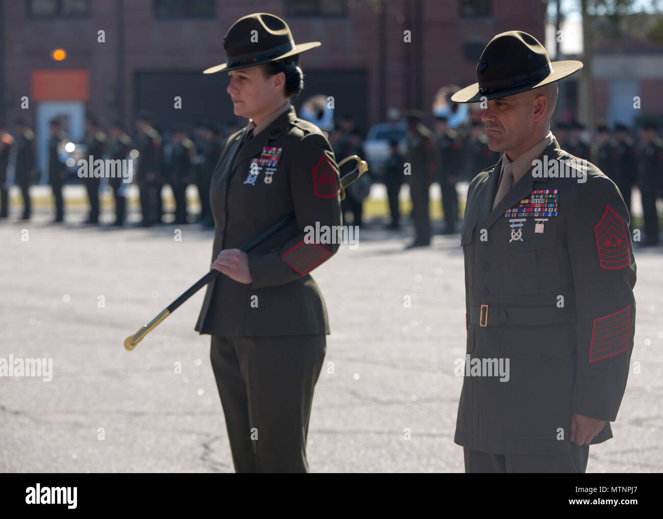 Sgt. Maj. Rafael Rodriguez stands at attention next to Sgt. Maj. Angela M. Maness during a relief and appointment ceremony Jan. 13, 2017, on Parris Island, S.C. Maness relinquished her post as the Marine Corps Recruit Depot Parris Island and Eastern Recruiting Region sergeant major to Rodriguez, who comes to the depot from Headquarters Regiment, 1st Marine Logistics Group. (Photo by Lance Cpl. Maximiliano Bavastro) Stock Photo