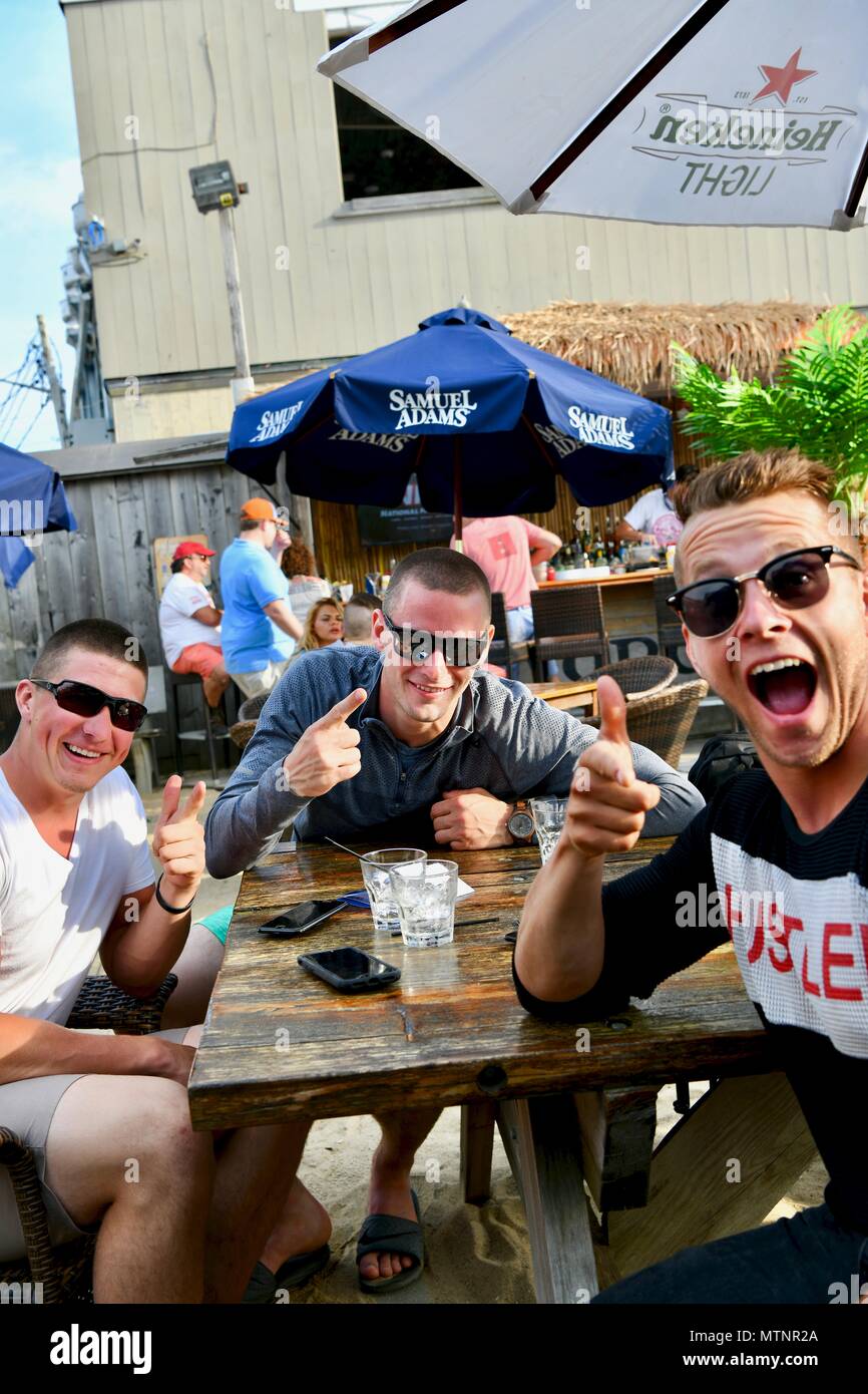Three men aged 21-30 having some beers at a restaurant with outdoor dining Stock Photo