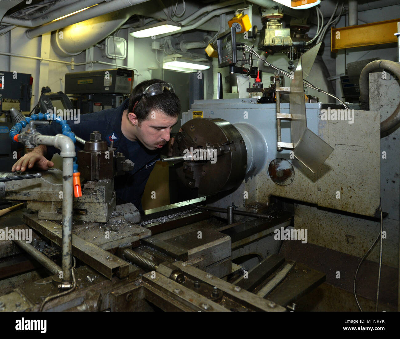 170113-N-HP188-026  ATLANTIC OCEAN (Jan. 13, 2017) – Machinery Repairman 2nd Class Tim Grover, a native of Hillsboro, Oregon, blows shavings off of a newly cut shaft in the Machine Shop aboard the Wasp-class multipurpose amphibious assault ship USS Bataan (LHD 5). Bataan is underway conducting Composite Training Unit Exercise (COMPTUEX) with the Bataan Amphibious Ready Group in preparation for an upcoming deployment.  (U.S. Navy photo by Mass Communication Specialist 3rd Class Mutis A. Capizzi/Released) Stock Photo