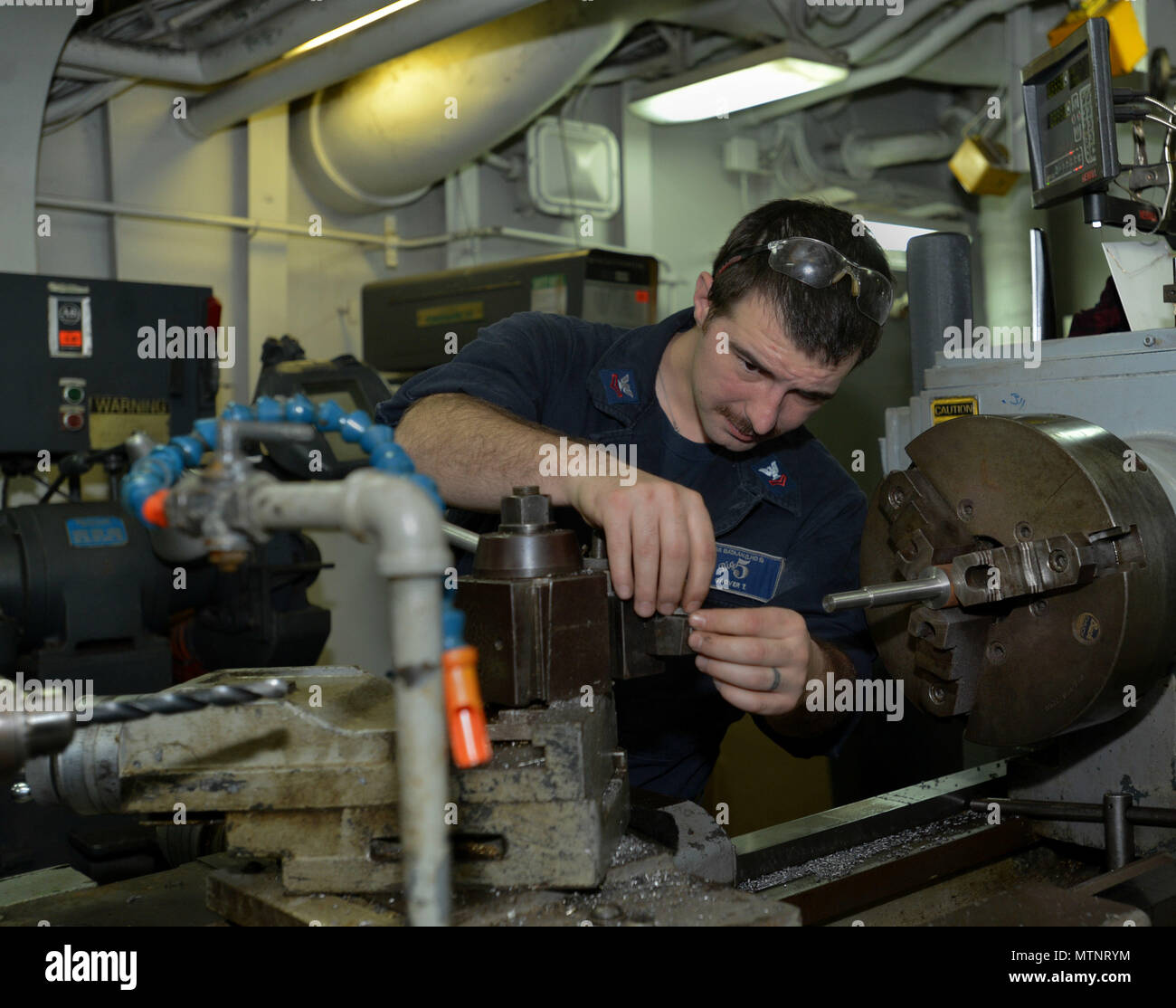 170113-N-HP188-033  ATLANTIC OCEAN (Jan. 13, 2017) – Machinery Repairman 2nd Class Tim Grover, a native of Hillsboro, Oregon, removes a bolt for cleaning from the cutter in the Machine Shop aboard the Wasp-class multipurpose amphibious assault ship USS Bataan (LHD 5). Bataan is underway conducting Composite Training Unit Exercise (COMPTUEX) with the Bataan Amphibious Ready Group in preparation for an upcoming deployment.  (U.S. Navy photo by Mass Communication Specialist 3rd Class Mutis A. Capizzi/Released) Stock Photo