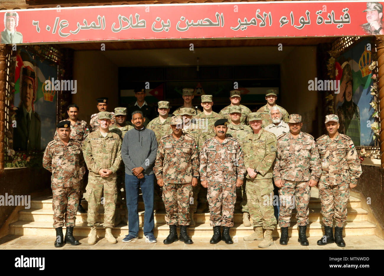 Members of the 60th Armor Brigade, 3rd Armor Division, Jordan Armed Forces- Arab Army and Alpha Company, 1st Battalion, 67th Armor Regiment, 3rd Brigade, 1st Armored Division pose in front of the 60th Armor Division headquarters in Jordan Jan. 9, 2017. The group had recently completed a joint training exercise to develop the planning skills of NCOs from Jordan and the U.S. in order to foster interoperability between the two countries militaries.  (U.S. Army photo by Sgt. 1st Class Kenneth Upsall) Stock Photo