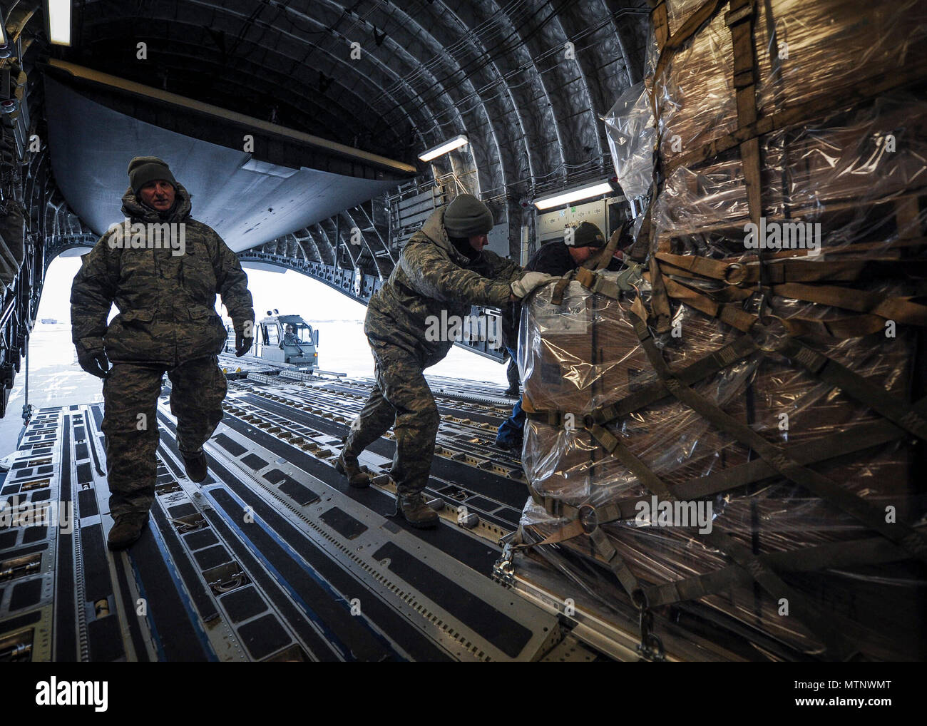 934th Airlift Wing Airmen at Minneapolis-St. Paul Air Reserve Station load humanitarian cargo onto a Joint Base Charleston C-17 Globemaster III Jan. 13, 2017. The 315th Airlift Wing flew more than 50,000 pounds of donated meals intended for refugees in northern Iraq. (U.S. Air Force photo by Senior Airman Tom Brading) Stock Photo