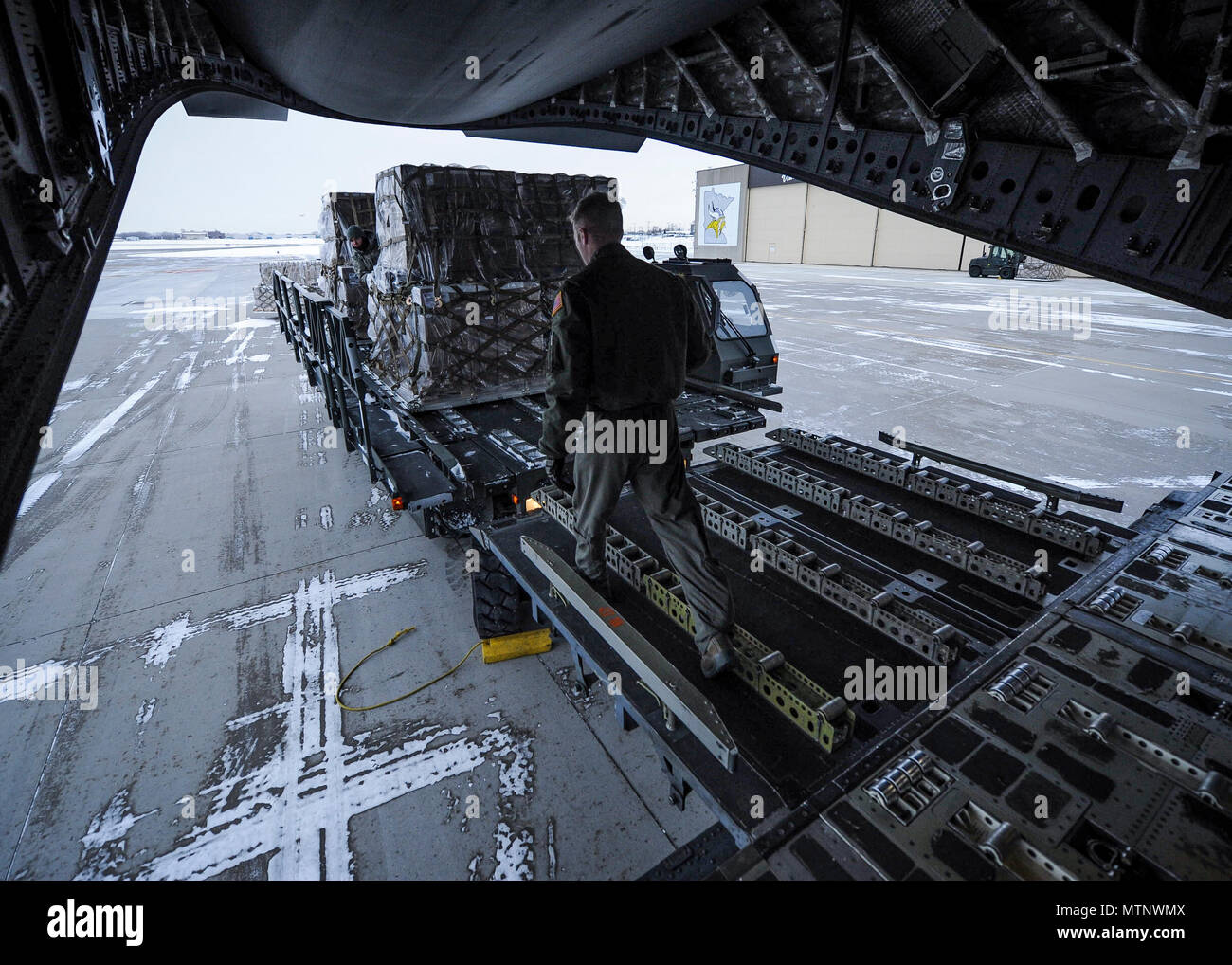 315th Airlift Wing loadmasters coordinate loading of humanitarian cargo onto a Joint Base Charleston C-17 Globemaster III Jan. 13, 2017 at Minneapolis-St. Paul Air Reserve Station, Minnesota.  The 315th AW hauled more than 50,000 pounds in donated meals to Ramstein Air Base, Germany. The cargo will be later delivered to refugees in northern Iraq. (U.S. Air Force photo by Senior Airman Tom Brading) Stock Photo
