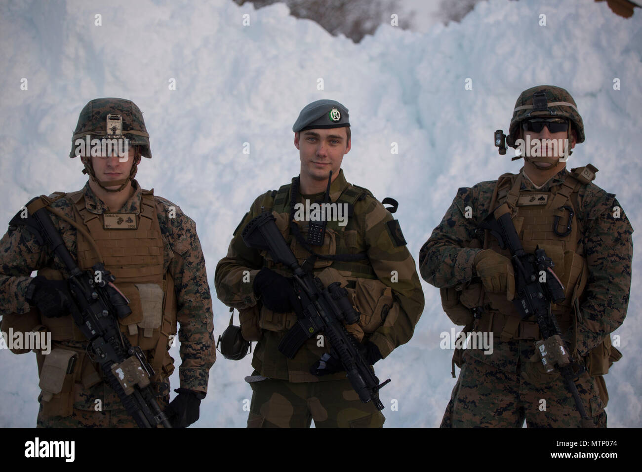 U.S. Marine Corporal Jacob Thomas and Cpl. Eduardo Duranespino stand alongside a Norwegian Army guard at Vaernes Garnison, Norway, Jan. 16, 2017. The Marines with Black Sea Rotational Force 17.1 arrived at Vaernes Garnison early in the morning as part of Marine Rotational Force Europe 17.1. (U.S. Marine Corps photo by Lance Cpl. Victoria Ross) Stock Photo