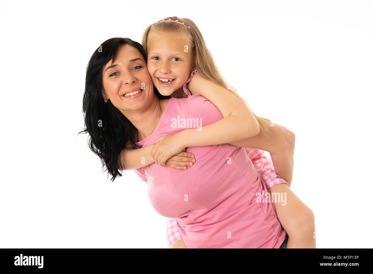 Portrait of a happy mother and cute blonde little girl hugging and looking cheerful at the camera in studio on white background. Happy family and good Stock Photo