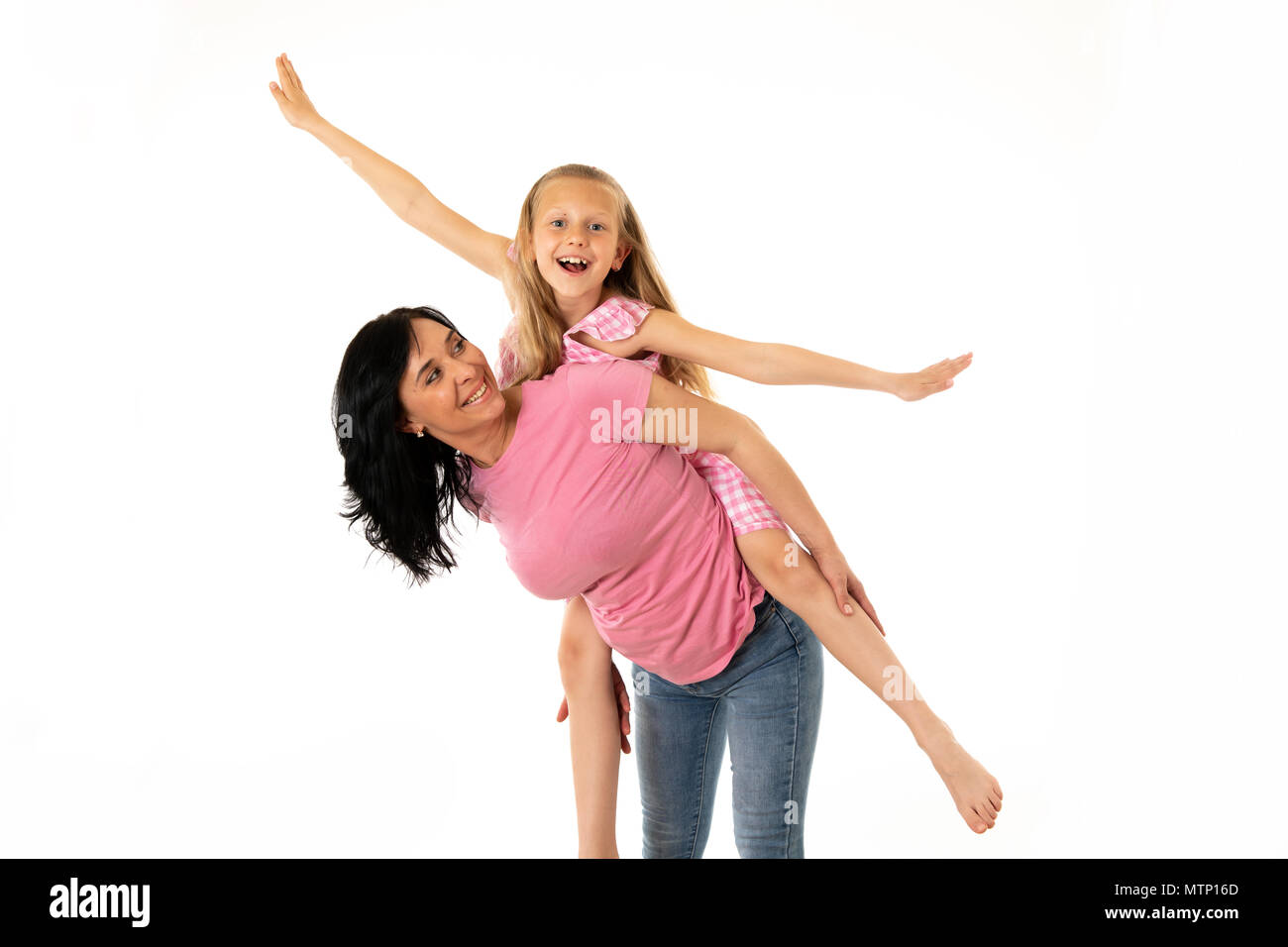 Portrait of a happy mother and cute blonde little girl hugging and looking cheerful at the camera in studio on white background. Happy family and good Stock Photo