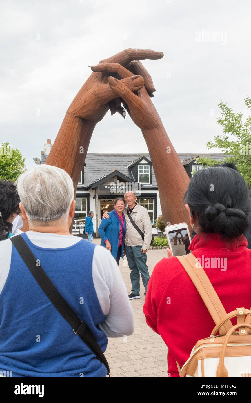 Tourists taking photographs of 'The Big Dance' sculpture by Ray Lonsdale in the Gretna Green sculpture garden, Scotland, UK Stock Photo