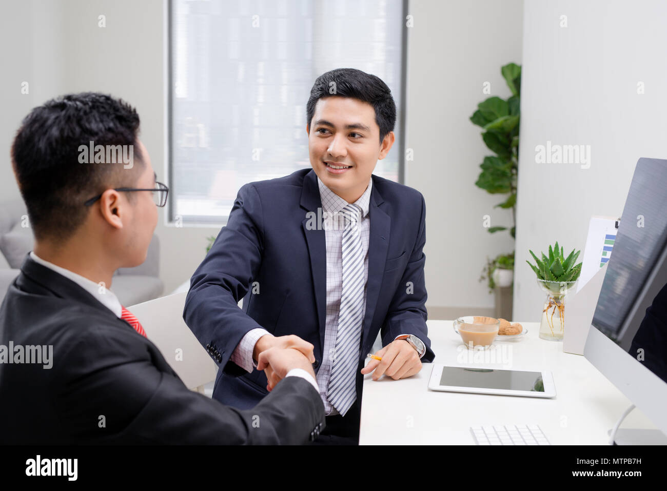 Salesman explaining his idea of overcoming crisis to co-worker Stock Photo