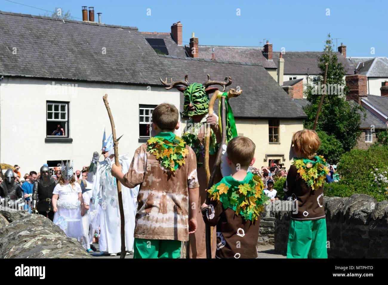Victory for the Green Man of Clun over the Ice Queen in a battle to banish winter and restore summer on medieval bridge in May Shropshire England UK Stock Photo
