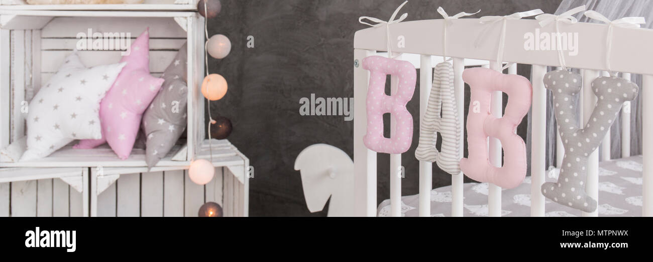 Close Up Of A Baby Room Corner With A Pastel Crib And A White