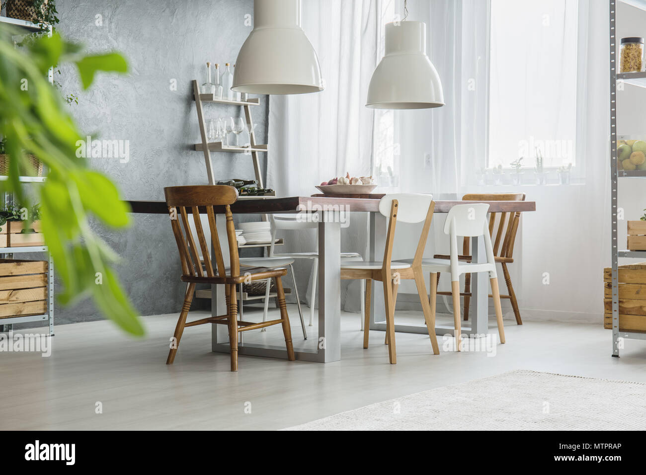 Bright grey and white dining room with big table Stock Photo - Alamy