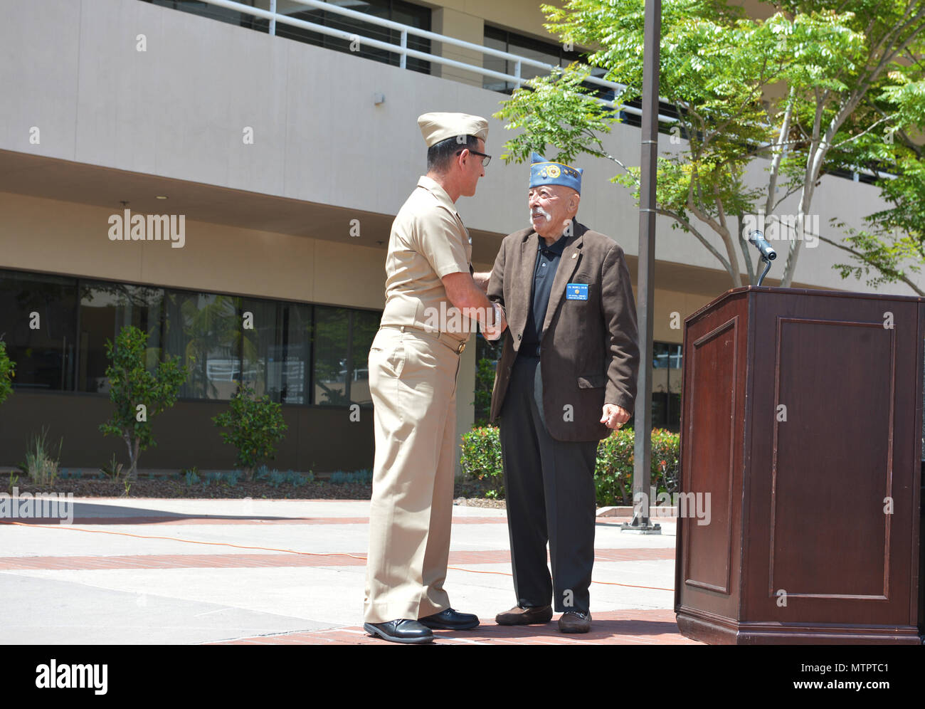 Capt. Joel Roos, commanding officer, Naval Medical Center San Diego (NMCSD), left, presents his command coin at NMCSD to retired Army Col. Maxwell Colon, Past National Commander of the Jewish War Veterans of the USA Foundation.  The Jewish War Veterans Post 385, had just donated various items, such as quilts and clothing, to the Armed Services YMCA, which is located at NMCSD.  The items will ultimately be delivered to the patients who receive their care at NMCSD. Stock Photo