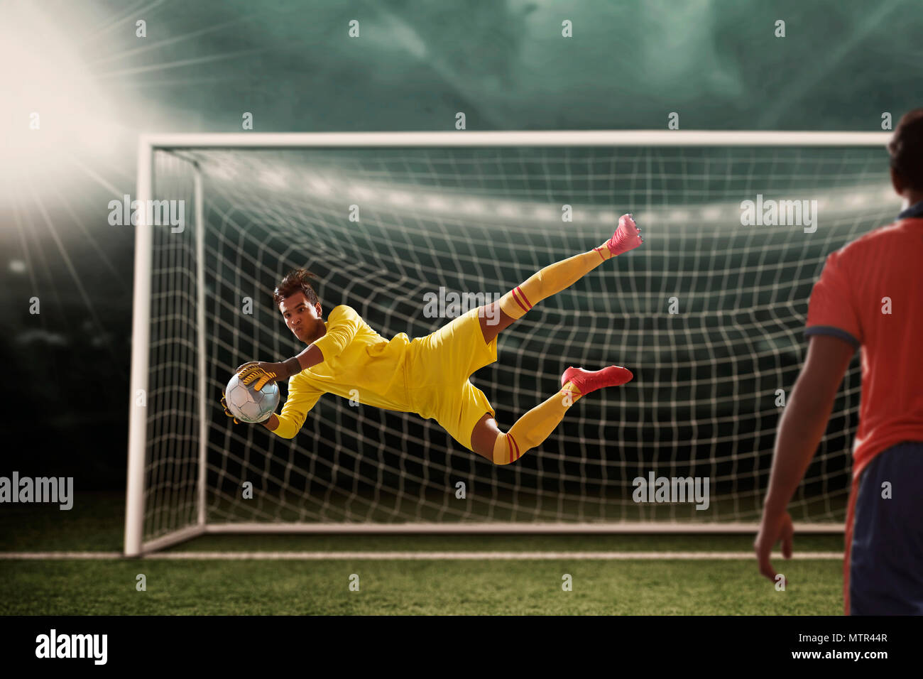 Goalkeeper catches the ball . At the stadium, in the spotlight Stock