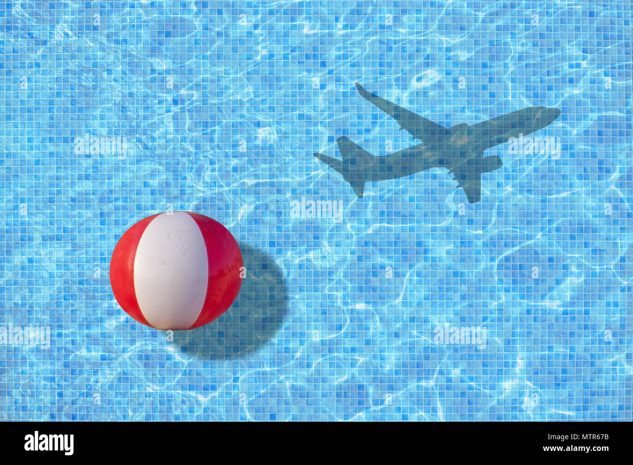 Vacation ends ball is left in pool and shadow of leaving airplane takes off concept for back to work, school start for example. Stock Photo