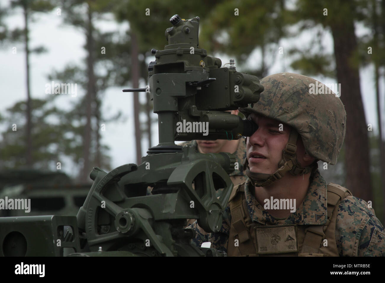 Lance Cpl. Christopher Ploof aims down the sight of an M777A2 towed 155mm howitzer at Camp Lejeune, N.C., Jan. 18, 2017. Ploof is attending the Artillery Training School as part of a certification course to become a gunner for the howitzer, which takes approximately two weeks to complete. Ploof is a field artillery cannoneer with 1st Battalion, 10th Marine Regiment, 2nd Marine Division. (U.S. Marine Corps photo by Lance Cpl. Juan A Soto-Delgado) Stock Photo